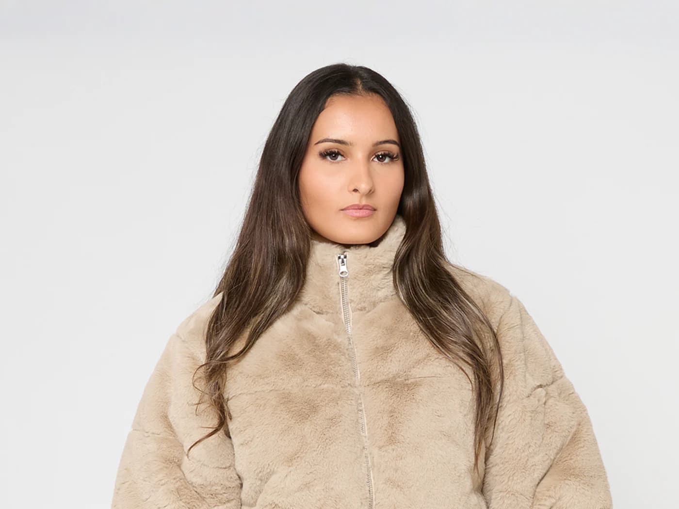 Model wearing a beige faux fur puffer jacket with a high collar.