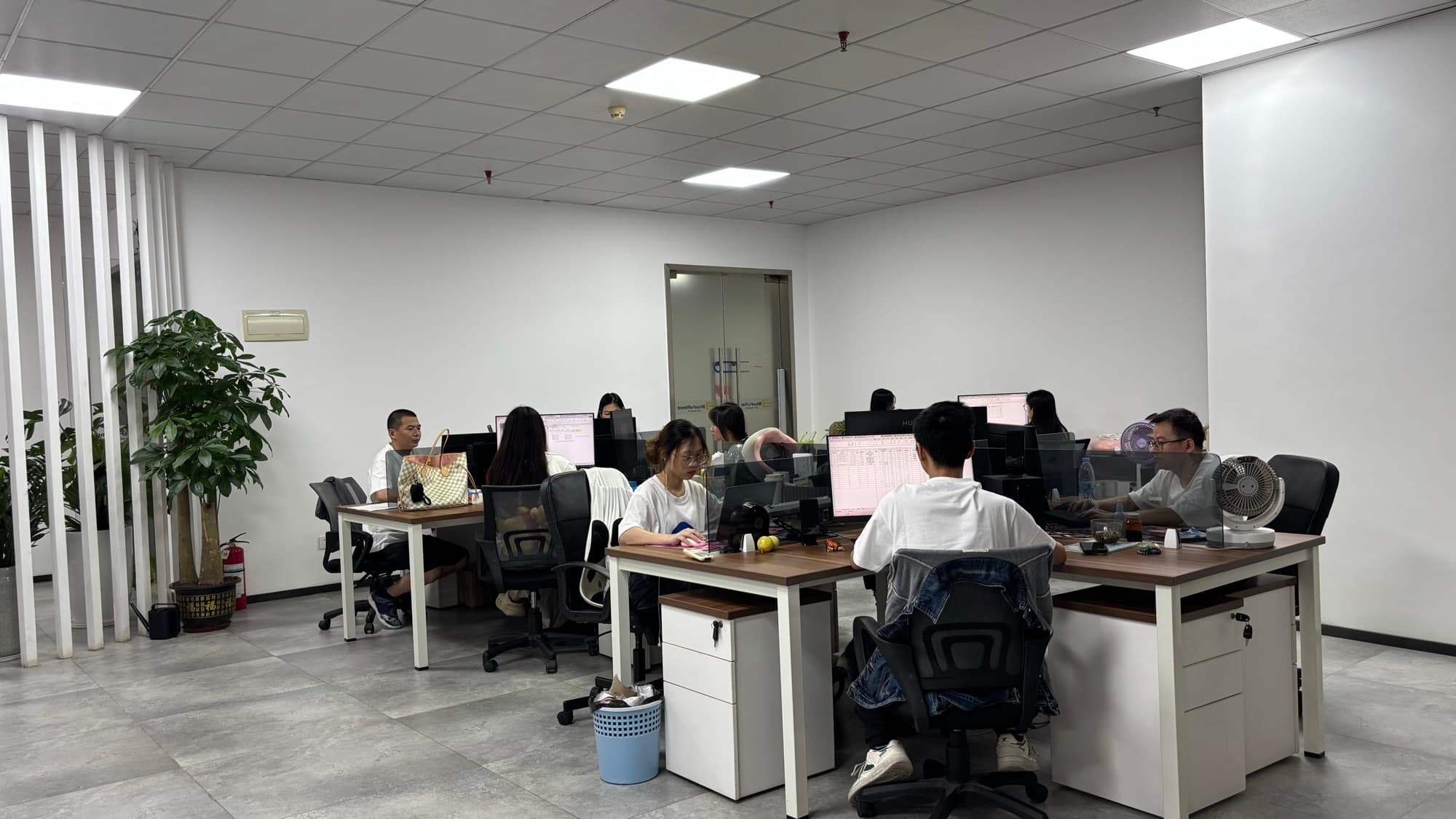 Members of the Neofulfill operations team working at their desks in the Shenzhen office.