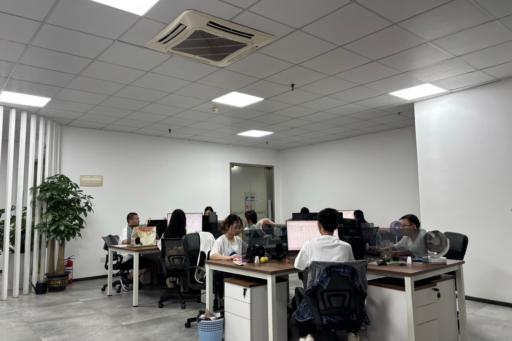 Members of the Neofulfill operating team working at their desks in the Shenzhen office.
