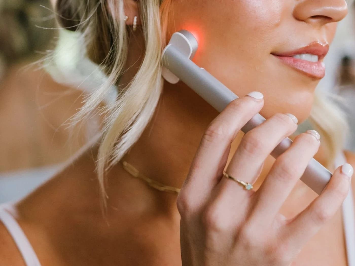 Red light facial wand for beauty dropshipping Beauty dropshipping suppliers red light facial wand being used on a woman's cheek.