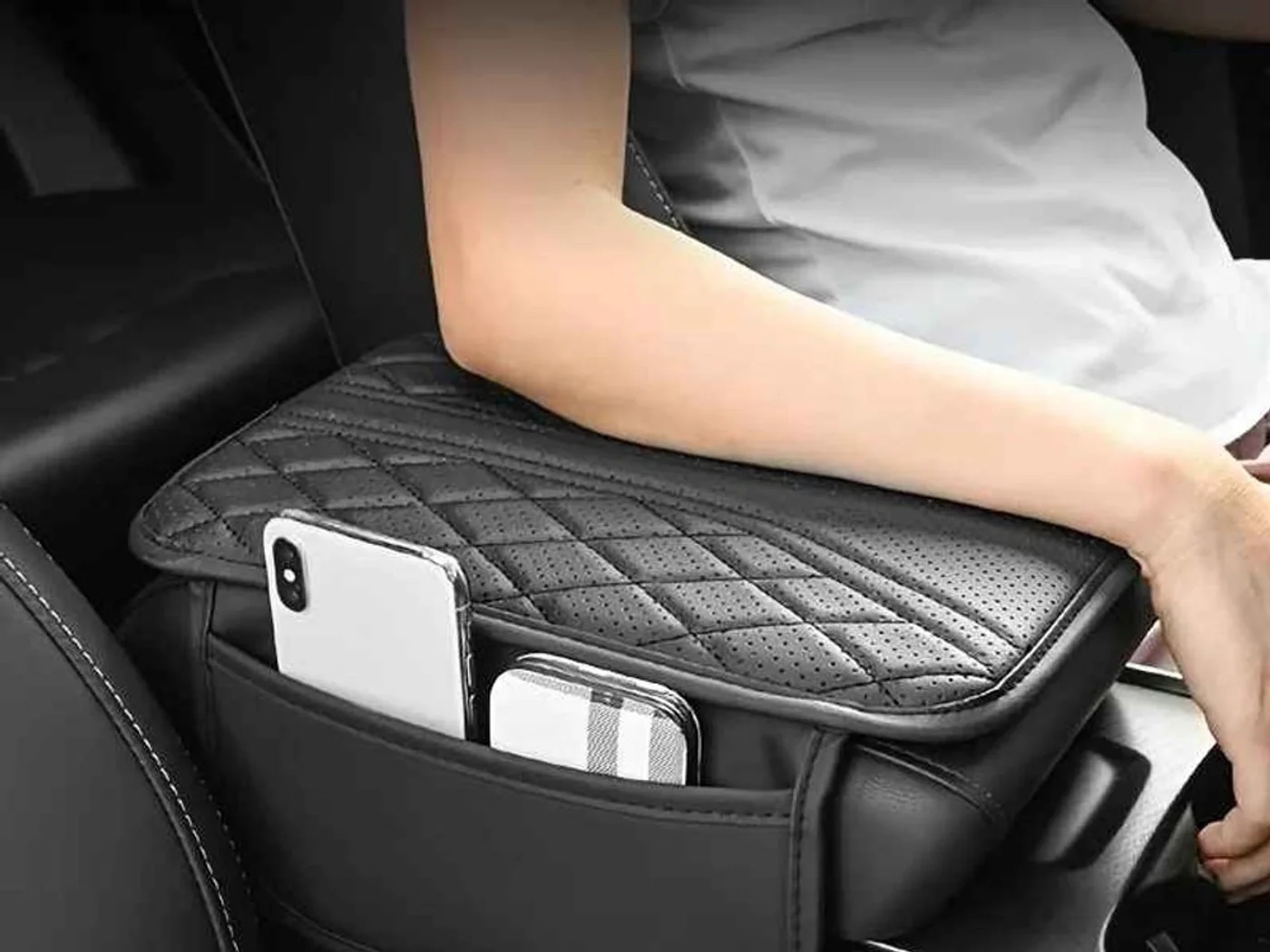 Padded car armrest organizer with storage pockets Black padded car armrest organizer with storage pockets between the seats.